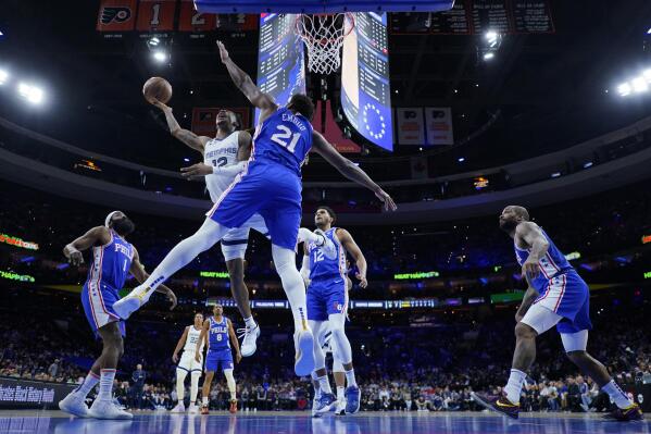 Memphis Grizzlies' Ja Morant, left, goes up for a shot against Philadelphia 76ers' Joel Embiid during the first half of an NBA basketball game, Thursday, Feb. 23, 2023, in Philadelphia. (AP Photo/Matt Slocum)