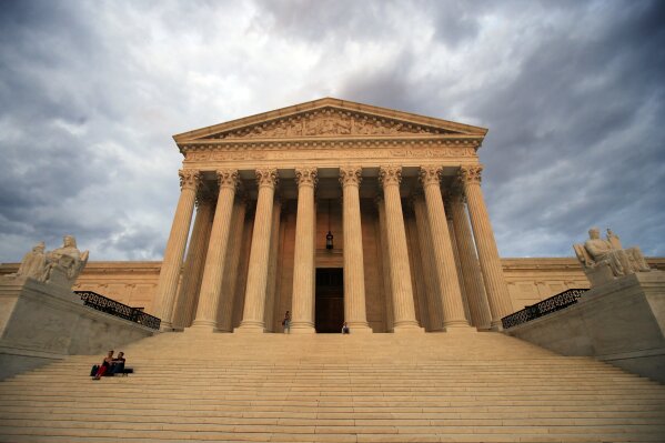 FILE - In this Oct. 18, 2018 file photo, the U.S. Supreme Court is seen at near sunset in Washington. Dozens of legal briefs supporting fired funeral director Aimee Stephens at the Supreme Court use “she” and “her” to refer to the transgender woman. So does the appeals court ruling in favor of Stephens that held that workplace discrimination against transgender people is illegal under federal civil rights law. But in more than 110 pages urging the Supreme Court to reverse that decision, the Trump administration and the funeral home where Stephens worked avoid those gender pronouns. (AP Photo/Manuel Balce Ceneta, File)