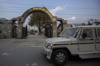 A paramilitary vehicle passes the front gate of Government Medical College in Srinagar, Indian controlled Kashmir, Tuesday, Oct. 26, 2021. Police have registered two separate cases under harsh anti-terror law against students and some staff of two medical colleges for celebrating Pakistan’s victory over archrival India in a T20 World Cup cricket game. (AP Photo/Mukhtar Khan)