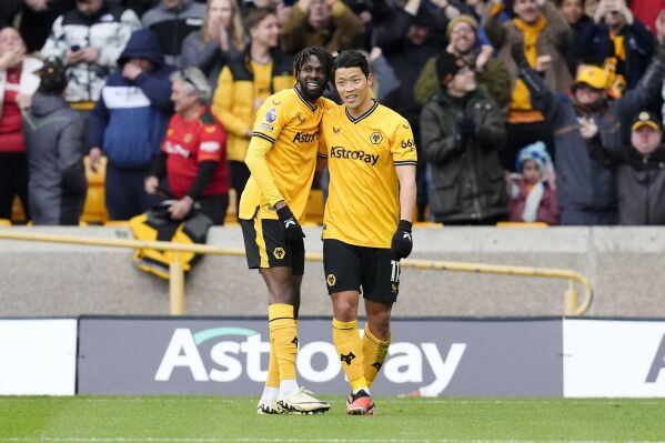 Wolverhampton Wanderers' Hwang Hee-Chan, right, celebrates scoring against Luton Town with teammate Boubacar Traore during the English Premier League soccer match at Molineux Stadium, Wolverhampton, England, Saturday April 27, 2024. (Nick Potts/PA via AP)