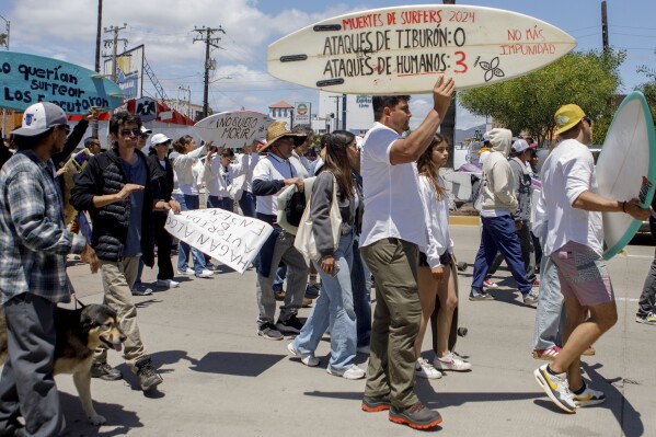 Locals march to protest the disappearance of foreign surfers in Ensenada, Mexico, Sunday, May 5, 2024. Mexican authorities said Friday that three bodies were recovered in an area of Baja California near where two Australians and an American went missing last weekend during an apparent camping and surfing trip. (AP Photo/Karen Castaneda)