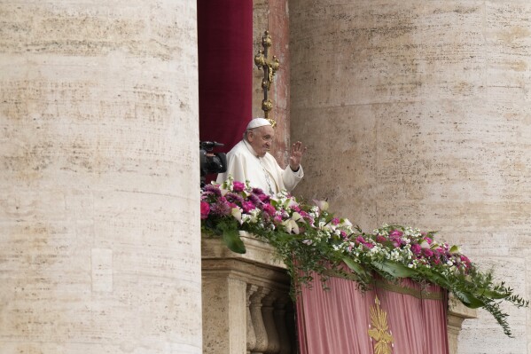 Pope Francis waves faithful from the central balcony of the St. Peter's Basilica prior to the the 'Urbi et Orbi' (To the city and to the world) blessing, at the Vatican, Sunday, March 31, 2024. (AP Photo/Alessandra Tarantino)