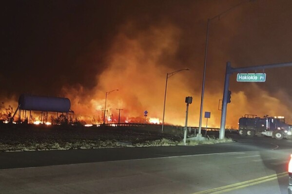 Esta foto proporcionada por el condado de Maui muestra llamas y humo llenando el cielo de incendios forestales en Hokiokio Place y Lahaina Bypass en Lahaina Bypass, el martes 8 de agosto de 2023, en Hawái. 