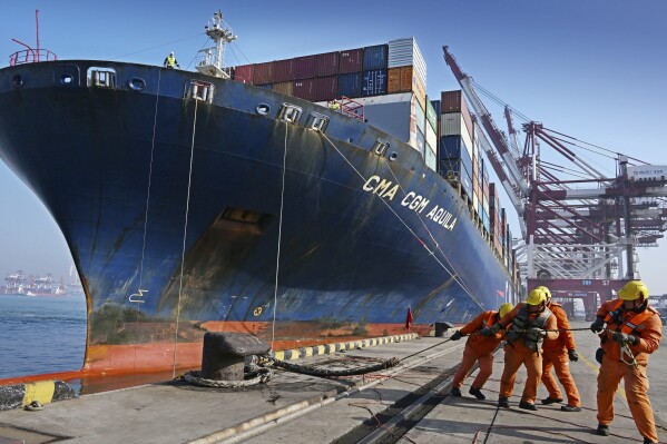 In this photo released by Xinhua News Agency, workers dock a container vessel at Qingdao Port, east China's Shandong Province on Feb. 11, 2024. China's exports and imports for the first two months of the year beat estimates, an indication that demand may be improving as Beijing attempts to speed up its economic recovery. (Li Ziheng/Xinhua via AP)
