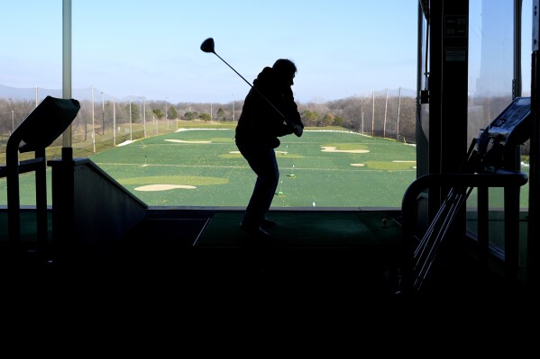 FILE - A golfer drives range balls on a warm day in Des Plaines, Ill., Feb. 1, 2024. On Friday, Feb. 16, 2024, the University of Michigan releases its preliminary reading of consumer sentiment for the month. (AP Photo/Nam Y. Huh, File)