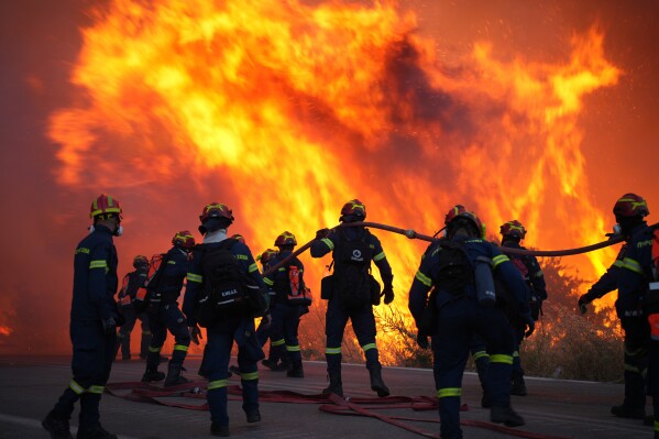 Firefighters battle with a large wildfire burning in Karyes village, on the eastern Aegean island of Chios, Greece, Sunday, June 22, 2025. (Pantelis Fykaris/Politischios.gr via AP)