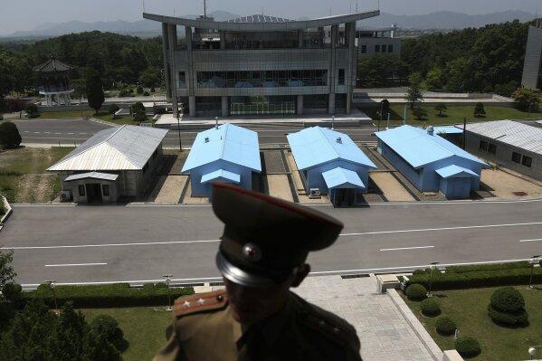                A South Korean building complex is seen in the background as North Korean soldiers guard the truce village at the Demilitarized Zone (DMZ) which separates the two Koreas in Panmunjom, North Korea, Wednesday, June 20, 2018. A tour guide Hwang Myong Jin, on the northern side of the Demilitarized Zone that divides the two Koreas, says that since the summits between North Korean leader Kim Jong Un and the presidents of South Korea and the United States, things have quieted down noticeably in perhaps the most iconic symbol of the one last place on Earth where the Cold War still burns hot. (AP Photo/Dita Alangkara)             