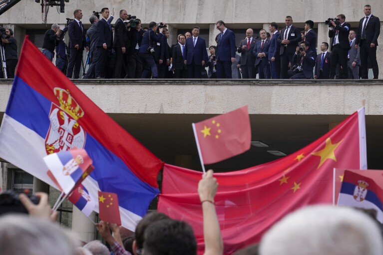 FILE - Chinese President Xi Jinping, centre left, and his Serbian counterpart Aleksandar Vucic, center right, greet the crowd as they arrive at the Serbia Palace in Belgrade, Serbia, Wednesday, May 8, 2024. Most countries in the European Union are making efforts to “de-risk” their economies from perceived threats posed by China. But Hungary and Serbia have gone in the other direction. They are courting major Chinese investments in the belief that the world’s second-largest economy is essential for Europe’s future. (AP Photo/Darko Bandic, File)