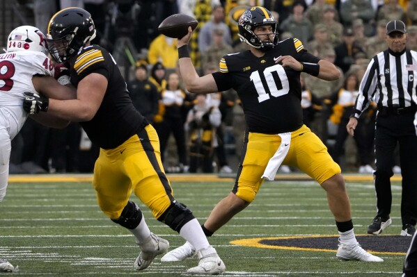 Iowa quareterback Deacon Hill (10) looks to throw a pass against Rutgers during the first half of an NCAA college football game, Saturday, Nov. 11, 2023, in Iowa City, Iowa. (AP Photo/Bryon Houlgrave)