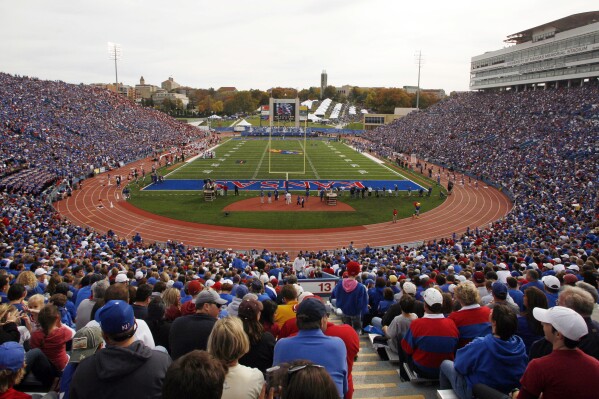 FILE- In this Oct. 24, 2009, file photo, a full house at Kansas Memorial Stadium watches the first half of an NCAA college football game between Oklahoma and Kansas in Lawrence, Kan. Kansas will play its entire schedule on the road next season, though some of those games will be played just down the road in venues that should create a home atmosphere. The school is building a new stadium. (AP Photo/Orlin Wagner, File)