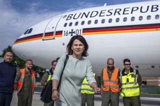 Minister for Foreign Affairs Annalena Baerbock walks through the airport of the airbase after her arrival from New York, in Bonn, Germany, Tuesday July 18, 2023. Germany's foreign minister was stuck in Abu Dhabi on Monday, Aug. 14, 2023, after a technical fault on her government plane — the latest in a succession of such incidents — forced it to return to the airport there rather than continuing to Australia. (Michael Kappeler/dpa via AP)