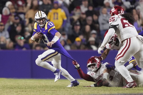 Oklahoma linebacker Danny Stutsman pulls the jersey of LSU quarterback Garrett Nussmeier (13) as he scrambles in the second half an NCAA college football game in Baton Rouge, La., Saturday, Nov. 30, 2024. LSU won 37-17. (AP Photo/Gerald Herbert)