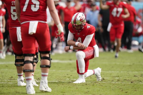Western Kentucky quarterback Bailey Zappe kneels after he threw a touchdown pass, his sixth of the game, during the second half of the Boca Bowl NCAA college football game against Appalachian State, Saturday, Dec. 18, 2021 in Boca Raton, Fla. Zappe threw for 422 yards and six touchdowns as the Western Kentucky beat Appalachian State 59-38. (AP Photo/Wilfredo Lee)