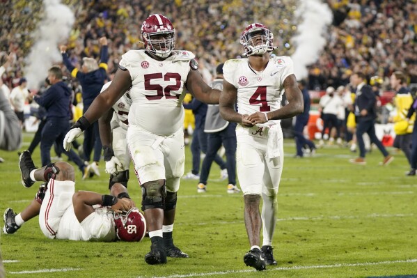 Alabama quarterback Jalen Milroe (4) and offensive lineman Tyler Booker (52) walk off the field after a loss to Michigan in the Rose Bowl CFP NCAA semifinal college football game Monday, Jan. 1, 2024, in Pasadena, Calif. (AP Photo/Mark J. Terrill)