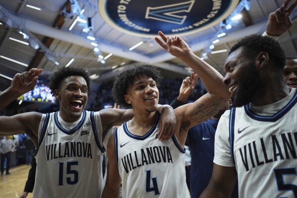 Villanova's Jordan Longino, from left, Tyler Perkins and Wooga Poplar celebrate after Villanova won an NCAA college basketball game against St. John's, Wednesday, Feb. 12, 2025, in Villanova, Pa. (AP Photo/Matt Slocum)