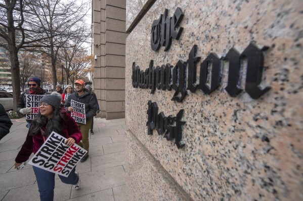FILE - Employees of the Washington Post picket outside the company's offices in downtown Washington, Thursday, Dec. 7, 2023, amid a one-day strike over labor issues. The Washington Post is completing buyouts to more than 200 staffers. (AP Photo/Mark Schiefelbein, File)