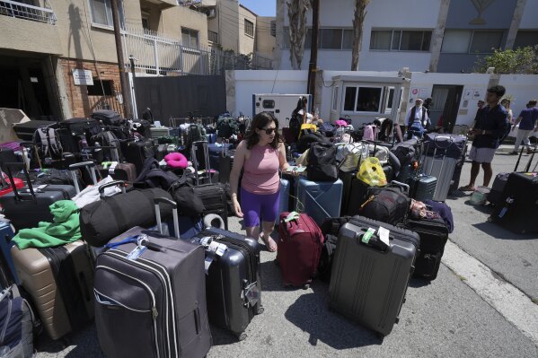 Luggage of evacuees from Israel are seen outside of a Jews community center, after their arrival from Israel to the port of Larnaca, Cyprus, Wednesday, June 18, 2025. (AP Photo/Petros Karadjias)