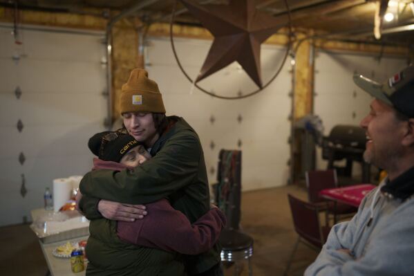 Lisa Martin, left, embraces son Shae Martin during a fish fry with Kelly Martin, right, Friday, April 19, 2024, in Hayward, Wis. (AP Photo/John Locher)