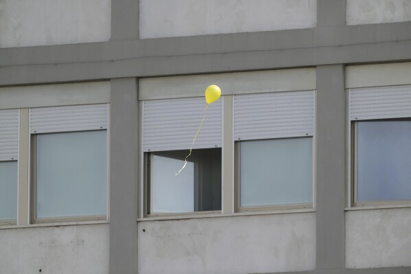 A balloon released by faithful flies near windows of the Agostino Gemelli polyclinic as people gather to pray for Pope Francis in Rome, Sunday, March 16, 2025. (AP Photo/Gregorio Borgia)