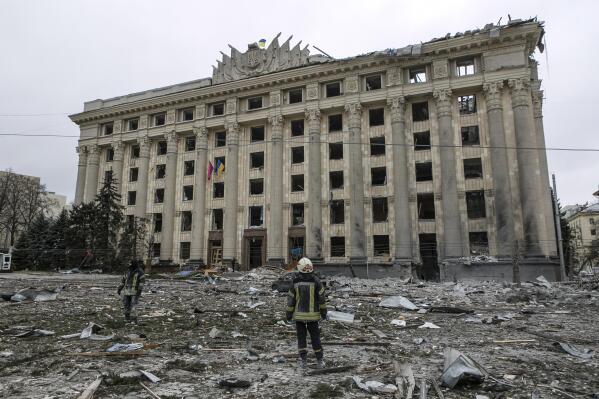 A member of the Ukrainian Emergency Service looks at the City Hall building in the central square following shelling in Kharkiv, Ukraine, Tuesday, March 1, 2022. Russian strikes pounded the central square in Ukraine’s second-largest city and other civilian sites Tuesday in what the country’s president condemned as blatant campaign of terror by Moscow. (AP Photo/Pavel Dorogoy)