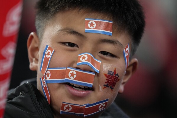 A fan has pasted North Korean flags on his face ahead of the FIFA World Cup 2026 and AFC Asian Cup 2027 preliminary joint qualification round 2 match between Japan and North Korea at the National Stadium Thursday, March 21, 2024, in Tokyo. (AP Photo/Eugene Hoshiko)