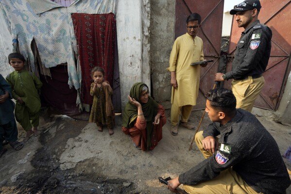 Pakistani police officers conducts biometric identification of a resident during a search operation against illegal immigrants at a neighbourhood of Karachi, Pakistan, Tuesday, Nov. 21, 2023. (AP Photo/Fareed Khan)