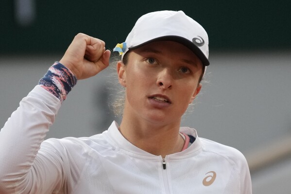 FILE - Poland's Iga Swiatek celebrates as she defeats China's Qinwen Zheng during their fourth round match of the French Open tennis tournament at Roland Garros stadium in Paris, Monday, May 30, 2022. Swiatek is one of the women to watch at the U.S. Open, which begins at Flushing Meadows on Aug. 28. (AP Photo/Christophe Ena, File)