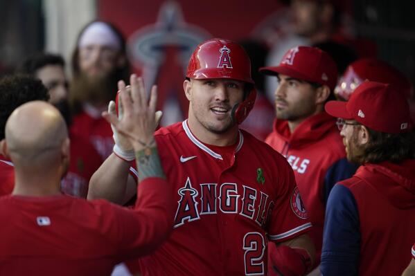 Los Angeles Angels' Mike Trout (27) celebrates in the dugout after scoring off of a single hit by Jared Walsh during the first inning of a baseball game against the Tampa Bay Rays in Anaheim, Calif., Tuesday, May 10, 2022. (AP Photo/Ashley Landis)