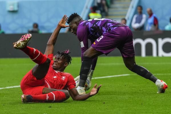 Switzerland's Breel Embolo reacts next to Cameroon's goalkeeper Andre Onana during the World Cup group G soccer match between Switzerland and Cameroon, at the Al Janoub Stadium in Al Wakrah, Qatar, Thursday, Nov. 24, 2022. (AP Photo/Petr Josek)