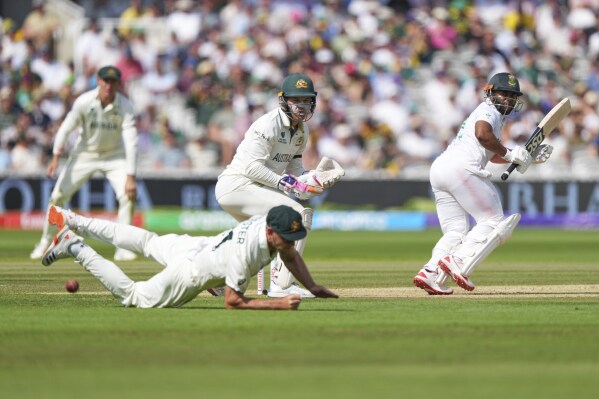 Australia's Beau Webster falls in an attempt to catch the ball after a shot play by South Africa's captain Temba Bavuma, right, on day three of the World Test Championship final between South Africa and Australia at Lord's cricket ground in London, Friday, June 13, 2025. (AP Photo/Kirsty Wigglesworth)