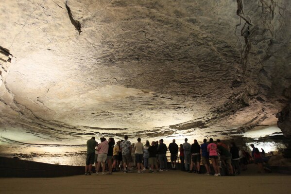 FILE - Tourists stand in the rotunda area of Mammoth Cave in Mammoth Cave National Park, Ky., on Aug. 3, 2011. Kentucky's tourism industry bounced back from the COVID-19 pandemic to post its best year on record in 2022, generating an economic impact of nearly $13 billion, the state said Tuesday, Aug. 8, 2023. (AP Photo/Ed Reinke, File)