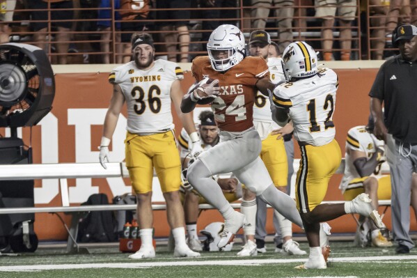 Texas running back Jonathon Brooks (24) carries past Wyoming's Chauncey Carter (12) during the first half of an NCAA college football game Saturday, Sept. 16, 2023, in Austin, Texas. (AP Photo/Michael Thomas)