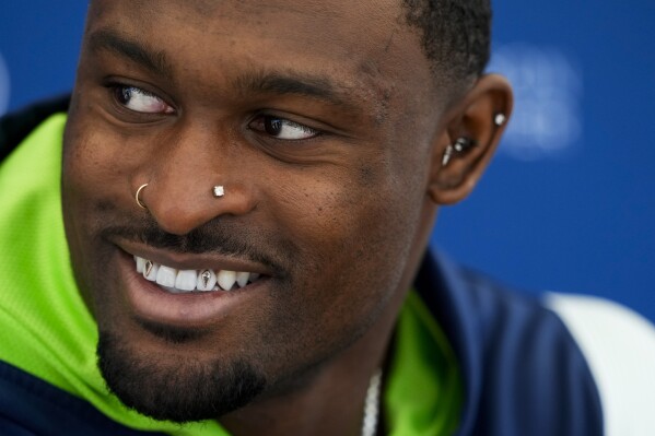 Seattle Seahawks wide receiver DK Metcalf smiles while speaking to the media before the NFL football team's practice Tuesday, June 11, 2024, in Renton, Wash. (AP Photo/Lindsey Wasson)