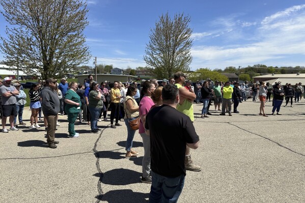 People wait for their children outside the Mount Horeb School District bus station in Mount Horeb, Wis., where students were taken after an active shooter situation at the middle school, Wednesday, May 1, 2024. Authorities said without giving details that the “alleged assailant” was harmed, and a witness said she had heard gunshots and saw dozens of children running. (AP Photo/Todd Richmond)