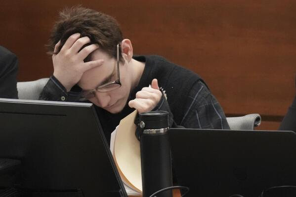 Marjory Stoneman Douglas High School shooter Nikolas Cruz holds his head as he looks through paperwork during the penalty phase of Cruz's trial at the Broward County Courthouse in Fort Lauderdale, Fla. on Wednesday, Aug. 31, 2022. Cruz previously plead guilty to all 17 counts of premeditated murder and 17 counts of attempted murder in the 2018 shootings. (Amy Beth Bennett/South Florida Sun Sentinel via AP, Pool)
