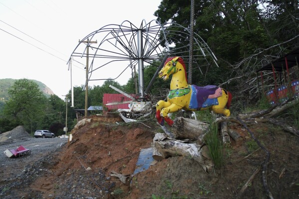 An antique carousel horse sits amid the wreckage of Bayou Billy's Country Fair amusement park in Chimney Rock Village, N.C., on Thursday, May 15, 2025. (AP Photo/Allen G. Breed)