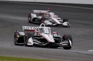 Josef Newgarden leads Will Power, of Australia, through a turn during an IndyCar auto race at Indianapolis Motor Speedway in Indianapolis, Friday, Oct. 2, 2020. (AP Photo/Michael Conroy)
