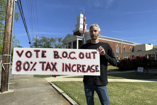Rob Romeijn protests property taxes outside Rockdale County offices in Conyers, Ga., on April 23, 2024. Romeijn says the increase in the taxable value of his house is unfair, but future increases in taxable values could be curbed if Georgia voters approve a referendum in November. (AP Photo/Jeff Amy)