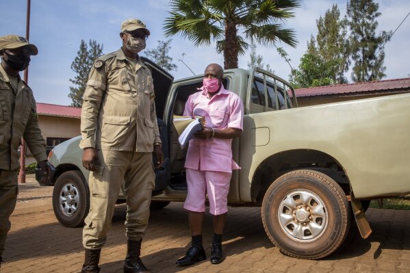 Paul Rusesabagina, whose story inspired the film "Hotel Rwanda", wears a pink prison uniform as he arrives for a bail hearing at a court in the capital Kigali, Rwanda Friday, Sept. 25, 2020. Rusesabagina admitted in court that he helped to form the National Liberation Front rebel group in order to assist Rwandan refugees, but denied that he supported any violence or killings. (AP Photo/Muhizi Olivier)