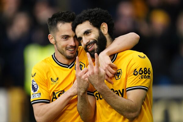 Wolverhampton Wanderers' Rayan Ait-Nouri, right, celebrates scoring their side's first goal of the game during the English Premier League soccer match between Fulham FC and Wolverhampton Wanderers at Molineux Stadium, in Wolverhampton, England, Saturday March 9, 2024. (Nick Potts/PA via AP)