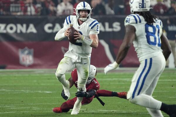 Indianapolis Colts quarterback Carson Wentz (2) is tripped up by Arizona Cardinals safety Budda Baker (3) during the second half of an NFL football game, Saturday, Dec. 25, 2021, in Glendale, Ariz. (AP Photo/Rick Scuteri)