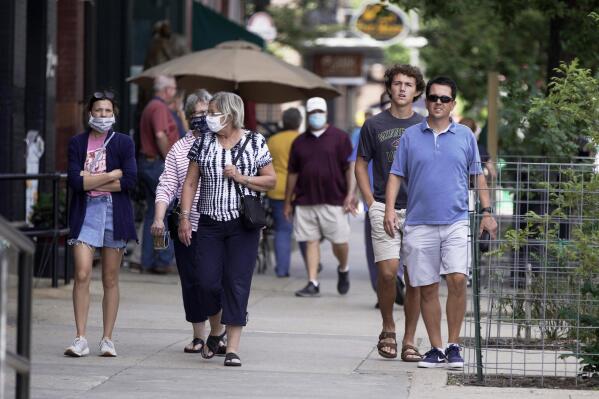 FILE - Pedestrians with and without face masks walk in downtown Omaha, Neb., Friday, July 31, 2020. Nebraska's unemployment rate fell to a mere 1.9% last month, the lowest a state has reached since data collection began in 1976, according to labor statistics released Friday., Nov. 19, 2021, The October rate reported by Nebraska's labor department and the Bureau of Labor Statistics marks the first time a state's unemployment rate has dropped below 2%. The unemployment rates have been even lower in the state's two largest metro areas, Omaha and Lincoln. (AP Photo/Nati Harnik File)