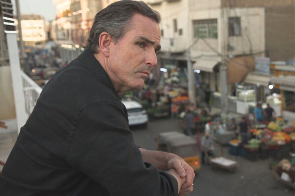 This image released by ABC News Studios shows Bob Woodruff on a balcony overlooking the Al–Sadiriyah marketplace in Baghdad, Iraq. Woodruff has returned to the Iraqi roadside where a bomb nearly killed him while on assignment for ABC News in 2006. “After the Blast: The Will to Survive,” which airs on ABC Friday at 8 p.m. Eastern and begins streaming on Hulu a day later. (ABC News Studios via AP)