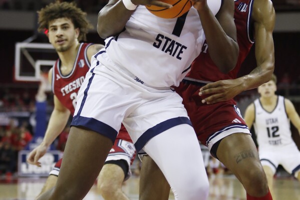 Utah State's Great Osobor puts up a shot against Fresno State's Leo Colimerio during the first half of an NCAA college basketball game in Fresno, Calif., Tuesday, Feb. 27, 2024. (AP Photo/Gary Kazanjian)