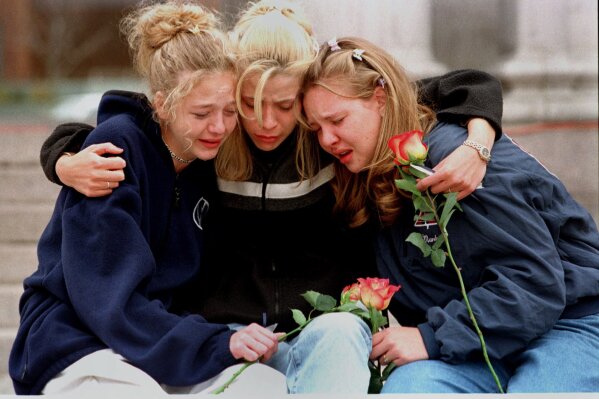 
              FILE - In this April 21, 1999, file photo, from left, Rachel Ruth, Rhianna Cheek and Mandi Annibel, all 16-year-old sophomores at Heritage High School in Littleton, Colo., console each other during a vigil service to honor the victims of the shooting spree in Columbine High School in the southwest Denver suburb of Littleton, Colo. Twelve students and one teacher were killed in a murderous rampage at the school on April 20, 1999, by two students who killed themselves in the aftermath. (AP Photo/Laura Rauch, File)
            