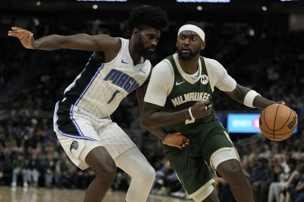 Milwaukee Bucks' Bobby Portis tries to get past Orlando Magic's Jonathan Isaac during the second half of an NBA basketball game Wednesday, April 10, 2024, in Milwaukee. (AP Photo/Morry Gash)