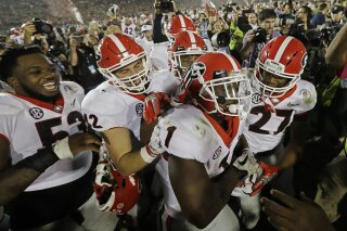 
              Georgia tailback Sony Michel (1) celebrates with teammates after scoring the game-winning touchdown in the second overtime period to give Georgia a 54-48 win over Oklahoma in the Rose Bowl NCAA college football game, Monday, Jan. 1, 2018, in Pasadena, Calif (AP Photo/Doug Benc)
            