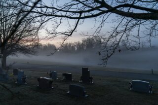 FILE - In this Wednesday, March 17, 2021 file photo, morning fog blankets a cemetery in West Virginia. The number of U.S. suicides fell nearly 6% in 2020 amid the coronavirus pandemic — the largest...