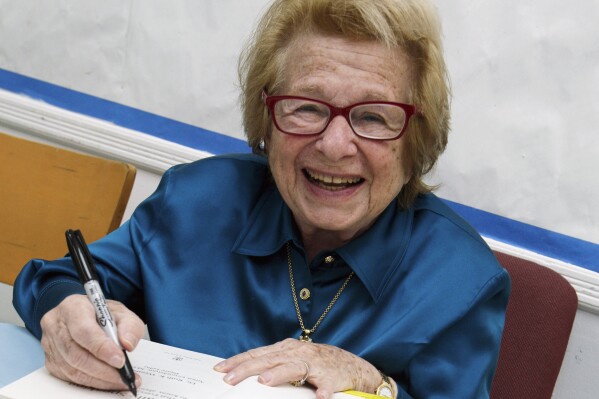 FILE - Dr. Ruth Westheimer signs a copy of her book "Sexually Speaking" in New York on April 26, 2012. (AP Photo/Richard Drew, File)
