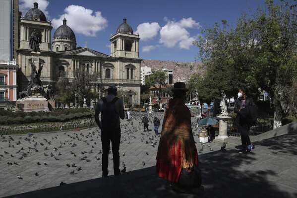 People gather in Plaza Murillo, the main square in downtown La Paz, Bolivia, Monday, Oct. 19, 2020, the morning after general elections. Results trickled in from Bolivia's presidential election, a high-stakes redo of last year's annulled ballot that saw president Evo Morales resign and flee the country. (AP Photo/Martin Mejia)
